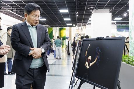 제8회 대한민국장애인국제무용제 사진전에 참석해 공연 사진을 감상하는 박강수 마포구청장
