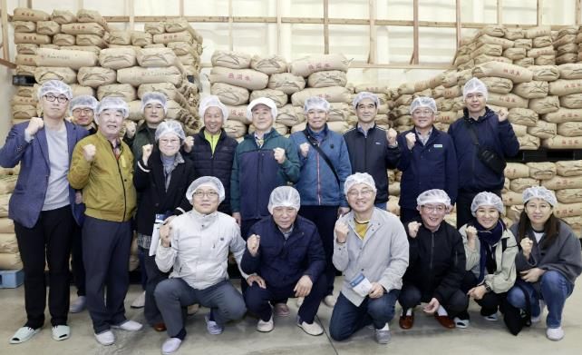 일본 니가타현 미나미우오누마시에 위치한 야이로물산을 방문한 칠곡군 농업 드림팀. 쌀 저장 창고 앞에서 단체 기념촬영을 하고 있다.